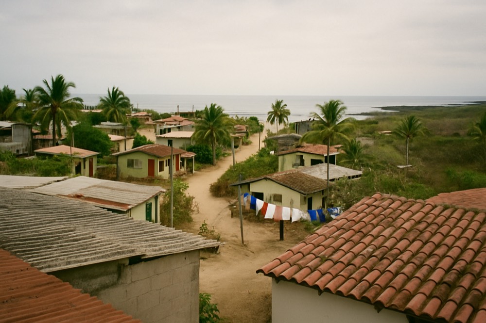 Red-tiled rooftops of a highland city spreading toward surrounding hills